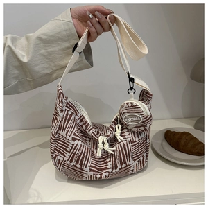 Detail of hobo bag with geometric print, wide strap and mini round pendant pouch