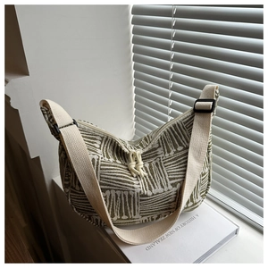 Detail of green striped hobo bag with adjustable wide strap and knotted zipper puller