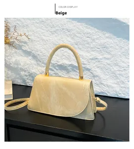 Dettaglio borsa a mano trapezoidale beige con finiture dorate e pelle PU testurizzata