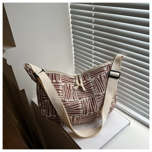 Close-up of striped canvas tote bag showing textured fabric and adjustable shoulder strap