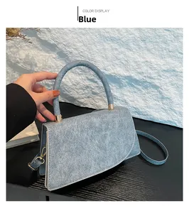 Vista dall'alto di una borsa in denim blu con dettagli dorati e un manico superiore