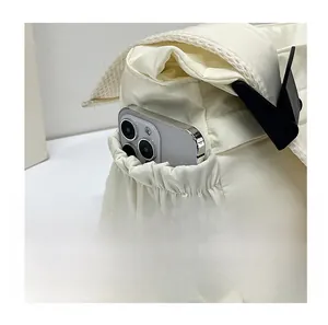 Detail der elfenbeinfarbenen Nylon-Umhängetasche mit elastischer Seitentasche für Handy