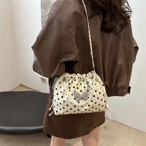 Polka dot bucket bag with silver butterfly charm and elegant pearl handle strap
