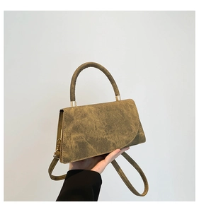 Dettaglio della borsa in pelle testurizzata vintage con patta geometrica asimmetrica unica