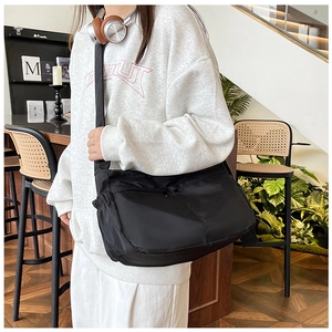 Verstellbarer breiter Gurt und Seitentaschen an einer großen schwarzen Nylon-Tasche