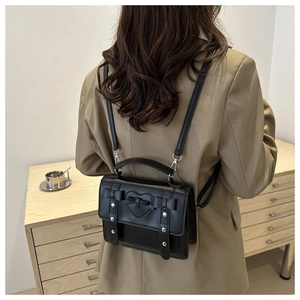 Rear view of a black Lolita-style PU leather backpack with heart embossing and bow details