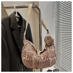 Detail of hobo bag with geometric woven pattern, wide strap and mini round pouch