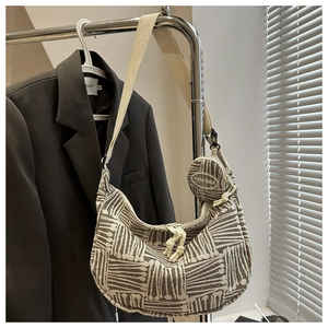 Detail of woven stripe tote bag with adjustable shoulder strap and small round coin purse