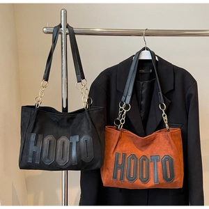 Close-up of matte suede tote bags with metal chain straps and HOOTO letter patches