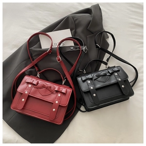 Flat lay of vintage PU leather heart messenger bags in red and black with bow details