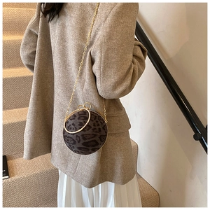 Detail of leopard print spherical handbag with gold chain and rhinestone ring handle
