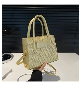 Détail du sac à bandoulière matelassé jaune clair avec poignées et sangle réglable