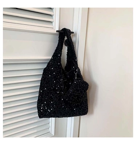 Close-up of black sequined tote bag featuring a matching coin purse on a silver chain