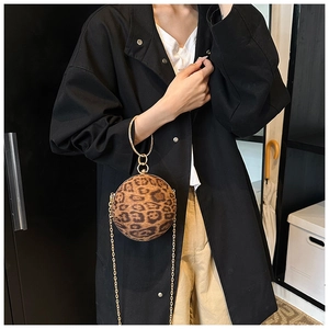 Close-up of leopard print round sphere bag with gold chain strap and metal handle