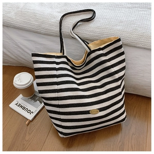 Detail of striped canvas tote bag showing interior lining and durable handle stitching