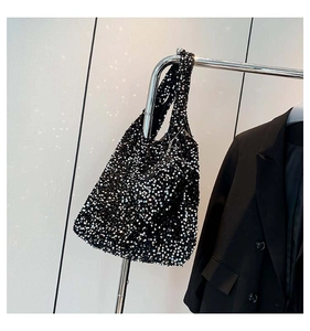 Close-up of sparkling black sequins on a large tote bag with metallic shimmer texture