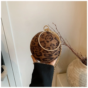 Detail of leopard print ball clutch bag with sparkling rhinestone handles and gold chain