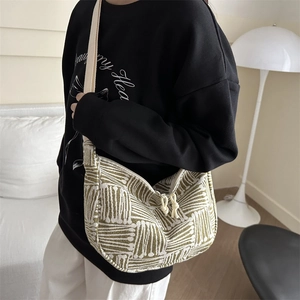 Olive green and cream striped hobo tote bag with woven texture and wide shoulder strap