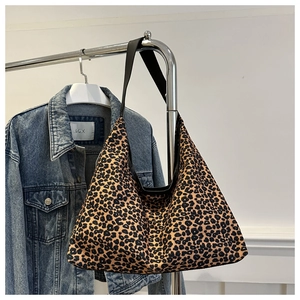 Detailed view of leopard print tote bag with thick black strap and spacious interior