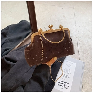 Detail of vintage brown suede shell bag with gold metal frame and white polka dot studs