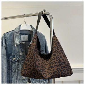 Macro detail of high-capacity leopard print hobo bag with a wide black shoulder strap