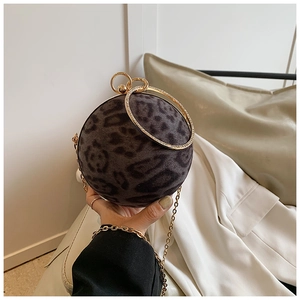 Detailed close-up of spherical leopard print evening bag with rhinestone ring handles