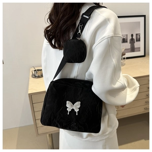 Detailed shot of black nylon crossbody bag with 3D white butterfly charm and coin pouch