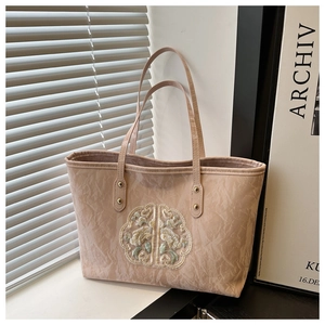 Détail du cabas rose clair avec texture froissée vintage et broderie florale fine
