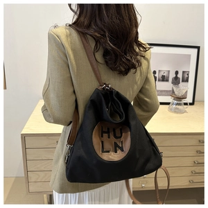 Canvas tote bag with HULN leather patch detail and brown shoulder strap on model