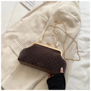 Detail of vintage brown velvet shell bag with pearl studs and golden flower handle