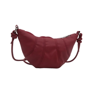 Deep burgundy leather half-moon shoulder bag with curved stitch detail and knot strap