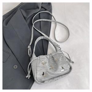 Sac à main gris argenté avec papillons métalliques et texture plissée élégante
