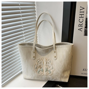 Détails de broderie de fleurs de style néo-chinois sur un sac fourre-tout aspect marbre