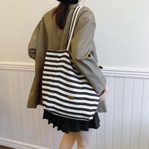 Striped canvas tote bag for women featuring a large capacity and a handmade logo plate