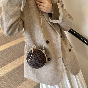 Fashionable leopard print spherical crossbody bag with gold chain strap on model