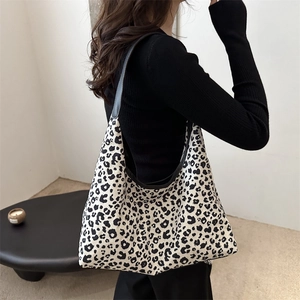 Chic leopard print hobo tote bag in beige canvas with black leather straps on model