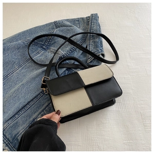Detail of color-block flap handbag with gold hardware against denim jacket backdrop