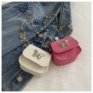 Detailed macro of white and pink mini crossbody bags with silver butterfly buckle