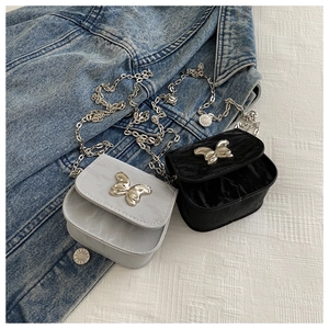 Close-up of mini flap bags with silver butterfly clasps and metallic chain straps