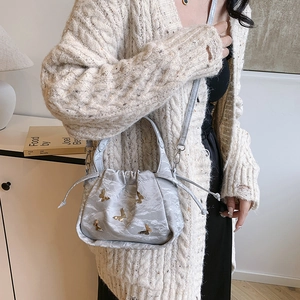 Sac bandoulière minimaliste en nylon gris avec détails papillons dorés en 3D