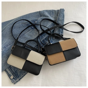 Close-up of minimalist color-block crossbody mini square bags on denim background