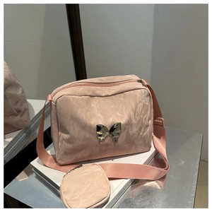 Detail of pink pleated crossbody bag with liquid metal butterfly buckle and mini pouch