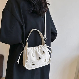 Sac bandoulière blanc à cordon, texture plissée et accents de papillons argentés