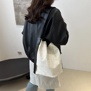 Minimalistische Canvas-Beuteltasche mit Lederriemen, präsentiert von einem Model im Studio