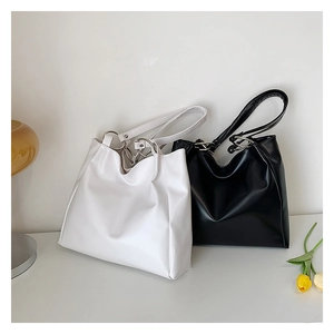 Detail of minimalist black and white tote bags with elegant metal ring strap connectors
