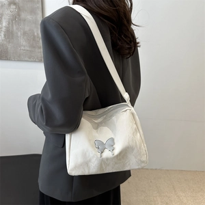 White large capacity shoulder bag with silver butterfly embroidery on a model