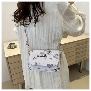 Detail of white crossbody bag with butterfly print, gold hardware and adjustable strap