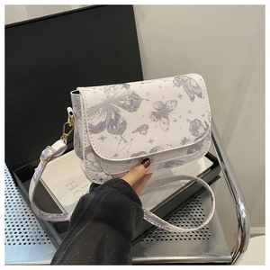 Detail of white butterfly print crossbody bag with golden metal buckle and printed strap