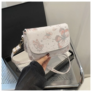 Detail of white PU shoulder bag featuring butterfly and star prints with gold hardware
