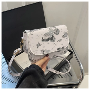 Detailed close-up of butterfly and star prints on a white leather small crossbody bag